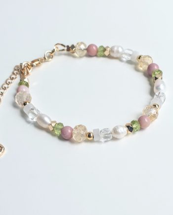 A handcrafted chain bracelet featuring Pearl, Citrine and Rhodonite with Peridot, White Jade and Clear Quartz by Red Lotus.