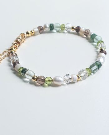 A handcrafted chain bracelet featuring Pearl, Peridot, Smoky Quartz, Moss Agate, Fluorite, Mother of Pearl and Clear Quartz by Red Lotus.